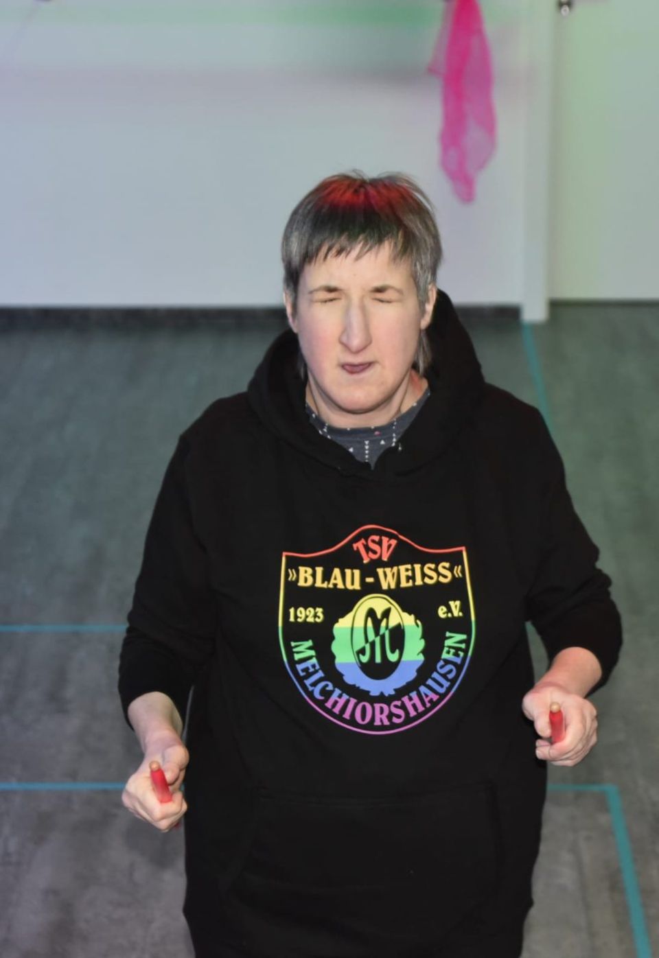 Trommlerin im Vereins-Hoodie lächelt in die Kamera