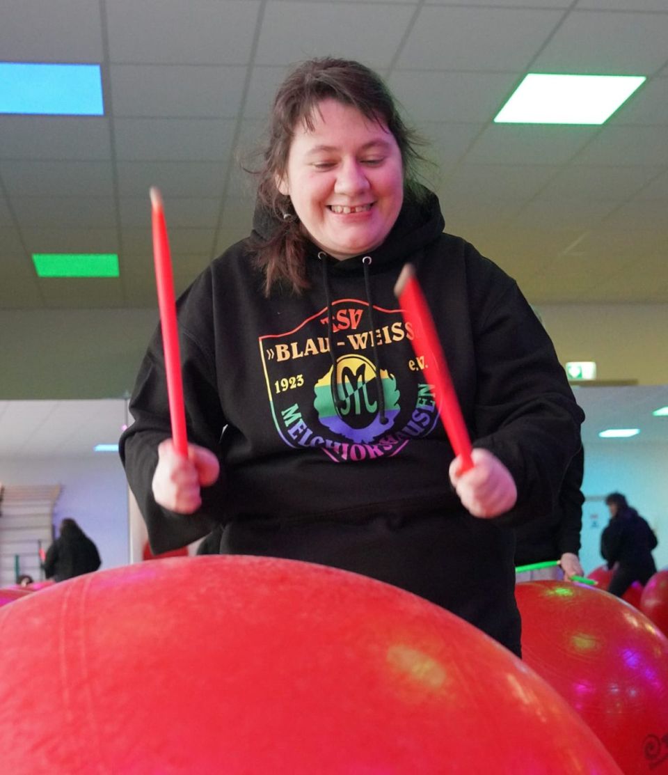 Trommlerin mit orangen Sticks vor ihrem Ball